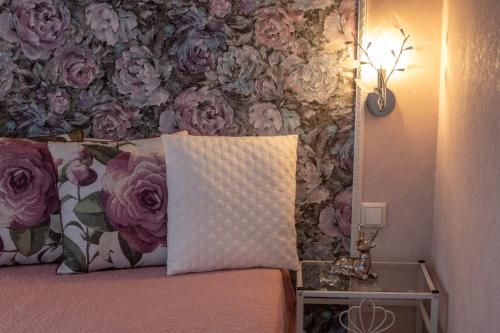 ein Schlafzimmer mit einer Blumenwand und einem Bett mit einem Kissen in der Unterkunft LULU APARTAMENT in Ventspils