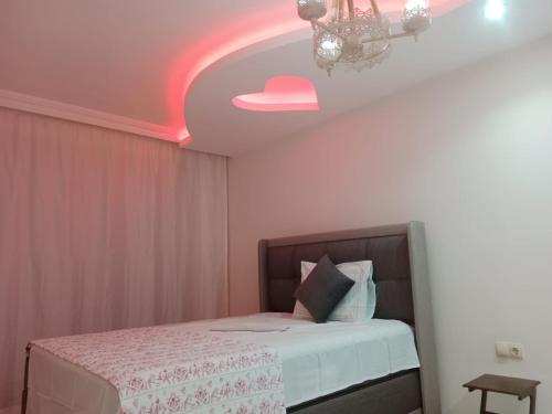 ein Schlafzimmer mit einem Bett mit einer rosa Decke in der Unterkunft Boztepe residence in Trabzon
