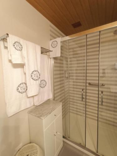 a bathroom with a shower and white towels at Casa da Aldeia 2021 in Escalhão