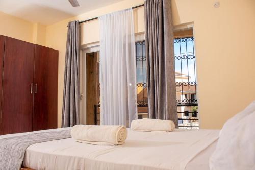 1 dormitorio con 2 camas y ventana en A Cozy 3 Bed Apartment With a Swimming Pool in Nyali - Beach Front en Mombasa
