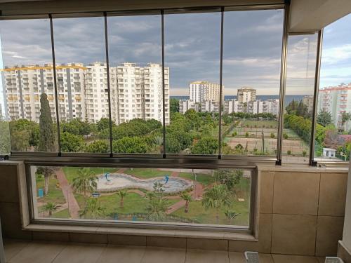 einen Blick auf einen Park aus einem Fenster in einem Gebäude in der Unterkunft QUEENABA SiTESi in Erdemli