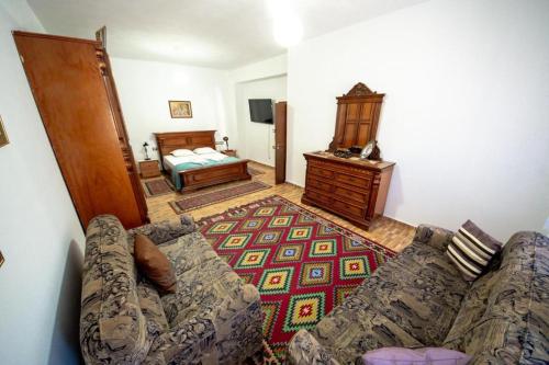 a living room with a couch and a bedroom at Nina's Guesthouse in Gjirokastër