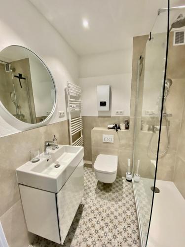 a bathroom with a sink and a toilet and a mirror at Moderne 3-Zi-Wohnung mit Meerblick direkt am Strand in Scharbeutz