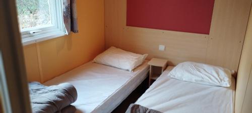 two beds in a small room with a window at Lou Rigaou in Aups