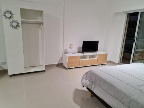 1 dormitorio con 1 cama y TV en un armario en Paseo De La Cisterna UF 320 en Buenos Aires