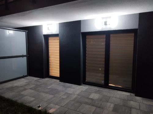 two garage doors on a building with lights on them at Apartament Zielone Tarasy in Rzeszów