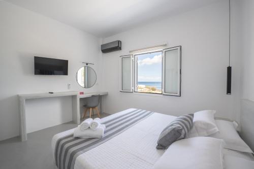 Habitación blanca con cama y ventana en Kamara Sea View Villa en Kamari