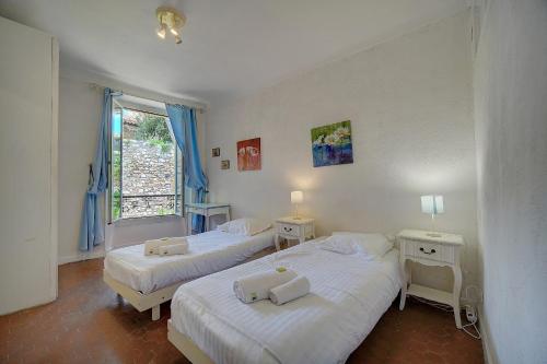une chambre avec deux lits et une fenêtre dans l'établissement IMMOGROOM - 5 min from beaches - Suquet - AC, à Cannes