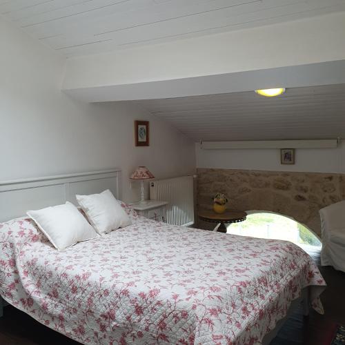 a bedroom with a large bed with a floral blanket at Chambres D'Hôtes Saint Jean in Saint-Jean-de-Blaignac