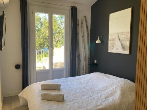 a bedroom with a bed with two towels on it at Les Restanques Maison 26 pinède 3 chambres in Grimaud