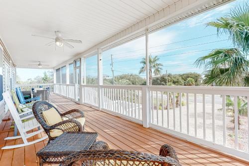 a porch with chairs and a ceiling fan at Almost Heaven in St. George Island