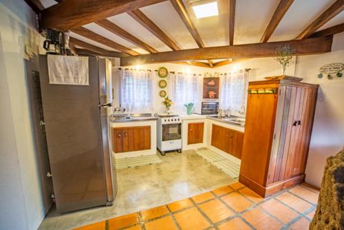 a kitchen with a refrigerator and a stove at Casa das Pedras in Monte Verde