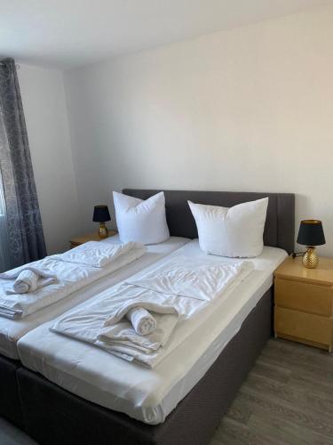 ein Bett mit weißer Bettwäsche und Handtüchern darauf in der Unterkunft Ferienwohnung Nähe Hannover Messe in Hannover