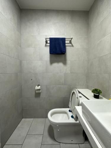a bathroom with a toilet and a sink and a blue towel at Sea View The Shore Luxury Newly Renovated Homestay in Kota Kinabalu