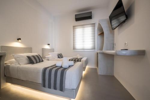 1 dormitorio con 2 camas y TV de pantalla plana en Kamara Sea View Villa en Kamari