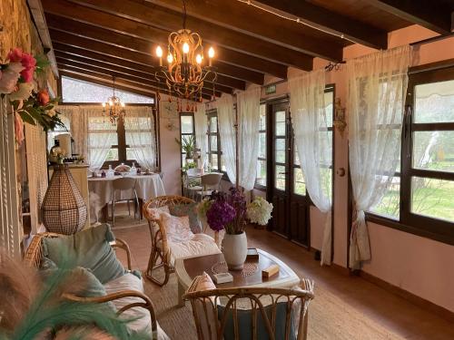 a living room with a chandelier and a table and chairs at Finca Vergel in Gata