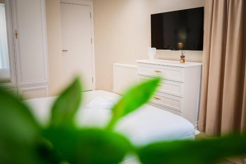 a room with a dresser with a television and a curtain at Apartament Zafi Lakeview in Constanţa