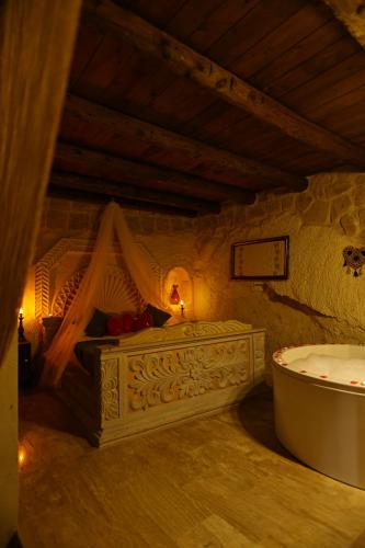 ein Bad mit Badewanne und ein Bett in einem Zimmer in der Unterkunft Nova Cave Hotel in Ortahisar