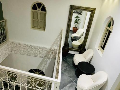 a bathroom with a tub and two chairs and a mirror at DAR Riad Jomana in Marrakech