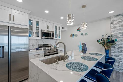 uma cozinha com um lavatório e cadeiras azuis em Sunset Paradise - Find yourself in Tampa em Tampa