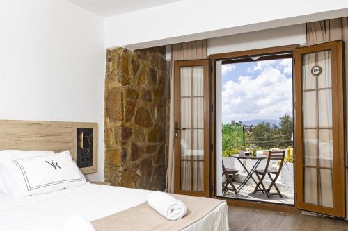 a bedroom with a bed and a balcony with a table at Bodrum Vera Hotel in Bodrum City