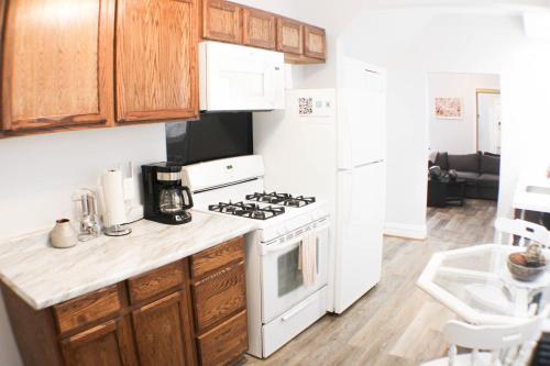 a kitchen with wooden cabinets and a white stove top oven at 2 BR - Off Street Parking - Amazing View Nearby in Pittsburgh