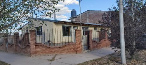 ein altes Backsteinhaus mit einem Zaun drum herum in der Unterkunft Cuarta División Apartments in Malargüe