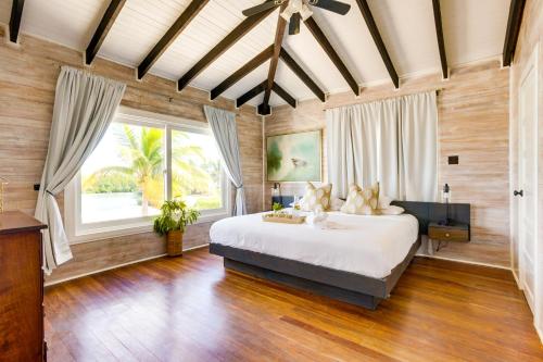 a bedroom with a large bed and a large window at Shaka Caye All inclusive Resort in Belize City