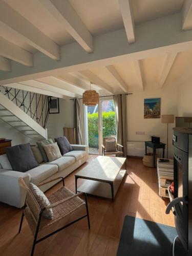 uma sala de estar com um sofá e uma mesa em Maison familiale 11 couchages, proche de La Palue em Crozon