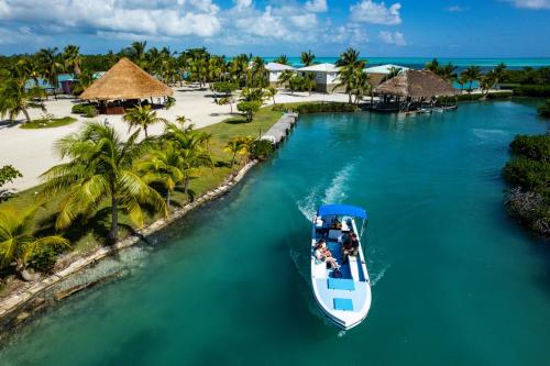 a boat in the water next to a beach at Shaka Caye All inclusive Resort in Belize City