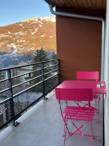 une table rose et une chaise sur un balcon dans l'établissement Apt With Panoramic View Near Vauban City, à Briançon
