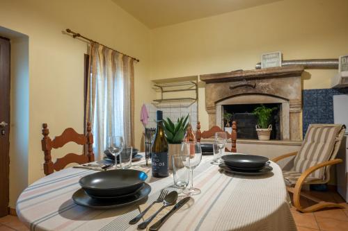 een eettafel met borden en glazen en een open haard bij WALNUT TREE VILLA in Archanes