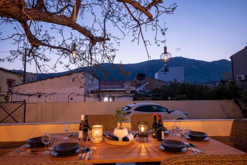 a wooden table with wine bottles and plates on it at WALNUT TREE VILLA in Archanes