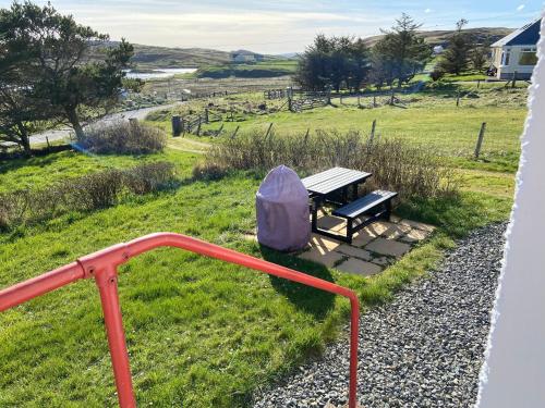 a bench sitting on the side of a field at Tigh-na-Greine in Carloway