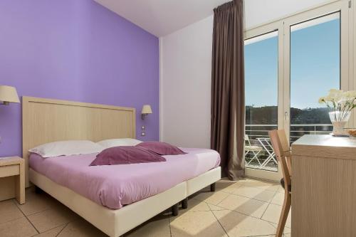 a purple bedroom with a bed and a balcony at De Maria House in SantʼAgata sui Due Golfi