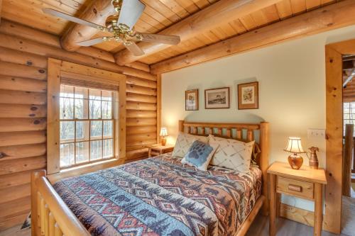 een slaapkamer met een bed en een plafondventilator bij Family Getaway Georgia Cabin with Outdoor Hot Tub in Clermont