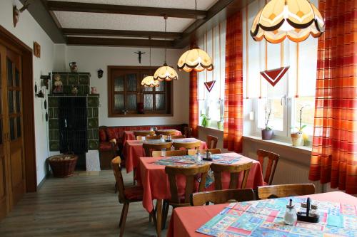 フォーエンシュトラウスにあるZum Schwarzen Bärenの窓のある部屋にテーブルと椅子が備わるレストラン