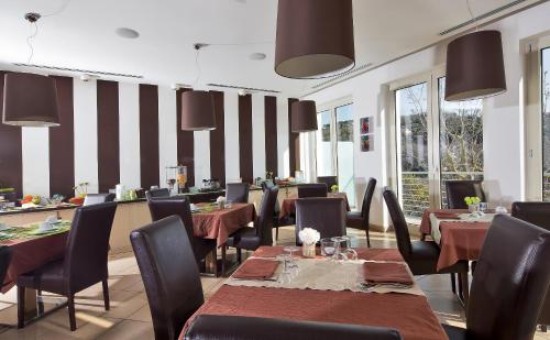 a dining room with tables and chairs and windows at De Maria House in SantʼAgata sui Due Golfi