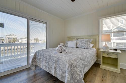a bedroom with a bed and a large window at Holden Beach Home on Intracoastal Waterway Canal! in Holden Beach