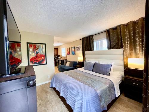 a bedroom with a bed and a flat screen tv at Sheridan Suites Apartments in Dania Beach