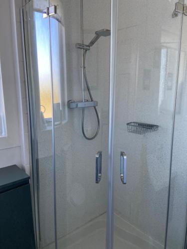 a shower with a glass door in a bathroom at Tigh-na-Greine in Carloway