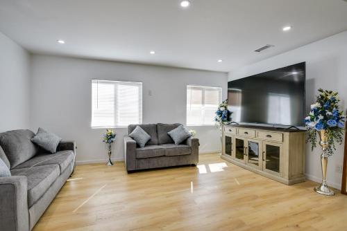 a living room with two couches and a flat screen tv at Pico Rivera Home with Patio about 20 Mi to Disney! in Pico Rivera