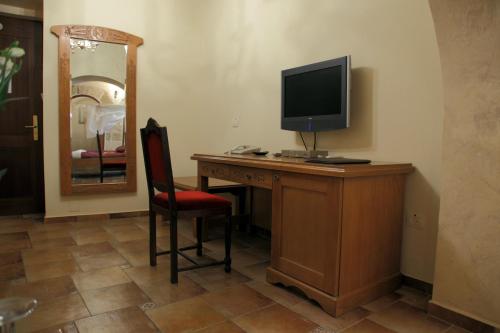 a room with a desk with a television and a chair at Akkotel-Boutique hotel in ‘Akko