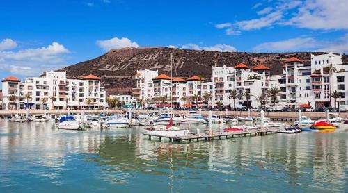 un grupo de barcos en un puerto deportivo con edificios en Marina Agadir Appartement en Agadir