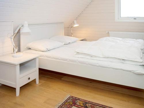 Sønder VorupørにあるFour-Bedroom Holiday home in Thisted 10のランプとテーブル付きの客室の白いベッド1台