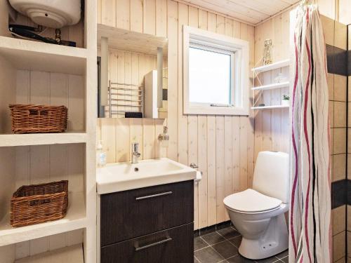 a small bathroom with a sink and a toilet at Holiday home Roslev IX in Roslev