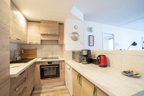 une cuisine avec des armoires en bois et un comptoir dans l'établissement Bright 66m At 600m From The Center Of Cannes, à Cannes