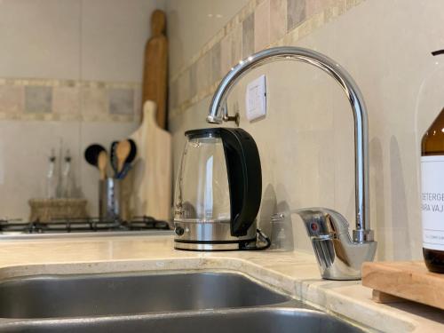 a kitchen sink with a tea kettle on a counter at Vicente López Premium in Salta