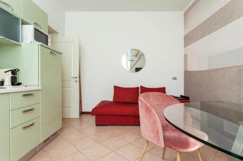 salon ze stołem i czerwoną kanapą w obiekcie Exquisite Stay Vannucci- Porta Romana w Mediolanie