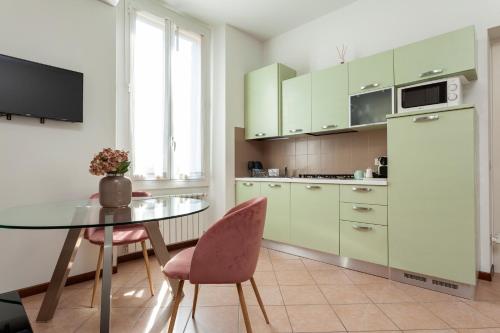 kuchnia ze stołem, krzesłami i lodówką w obiekcie Exquisite Stay Vannucci- Porta Romana w Mediolanie